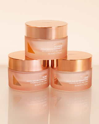 Three rose gold skincare jars stacked on a beige background