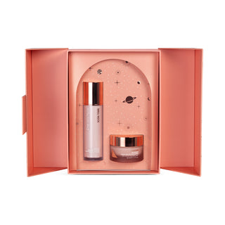 Skincare box open showcasing two skin products. The serum is in a pump bottle with gold lid and the moisturizer is in a jar with a gold lid