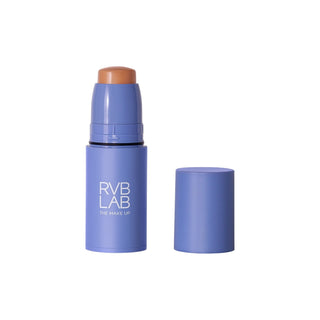 Purple RVB LAB makeup stick with medium toned cream tip exposed, shown upright beside its matching cap.