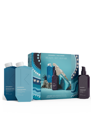 Kevin Murphy product set of 3 products. Shampoo in light blue bottle, conditioner in dark blue, and a treatment oil in a purple bottle. The products are in front of a blue package patterned box and the background is white. 
