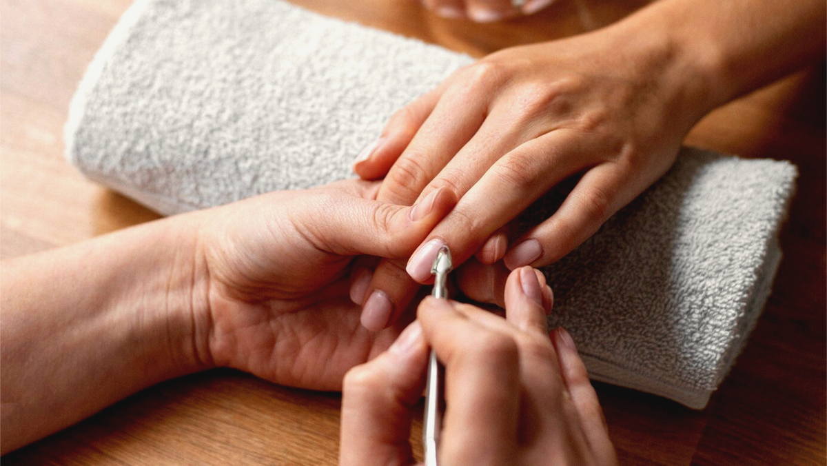 Person getting a manicure with a towel on the table