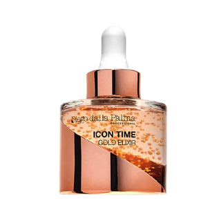 A bottle of Icon Time Gold Elixir serum with a rose gold metallic cap and white dropper. The bottle is clear and the serum has a gold colour to it with microencapsulated hyaluronic acid beads throughout. The serum is set against a solid white background.