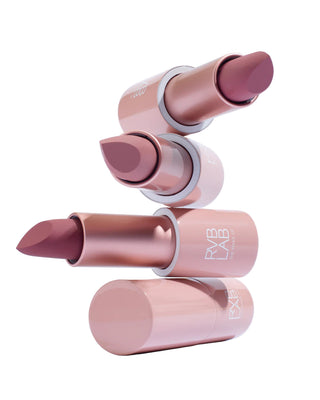 Stack of pink lipsticks with visible brand name on a light gray background